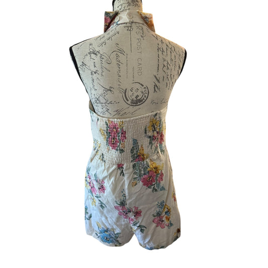 Back of Floral romper on a mannequin with a vintage-style background