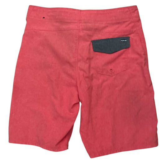 Red board shorts with a dark gray back pocket, shown from the back on a white background.