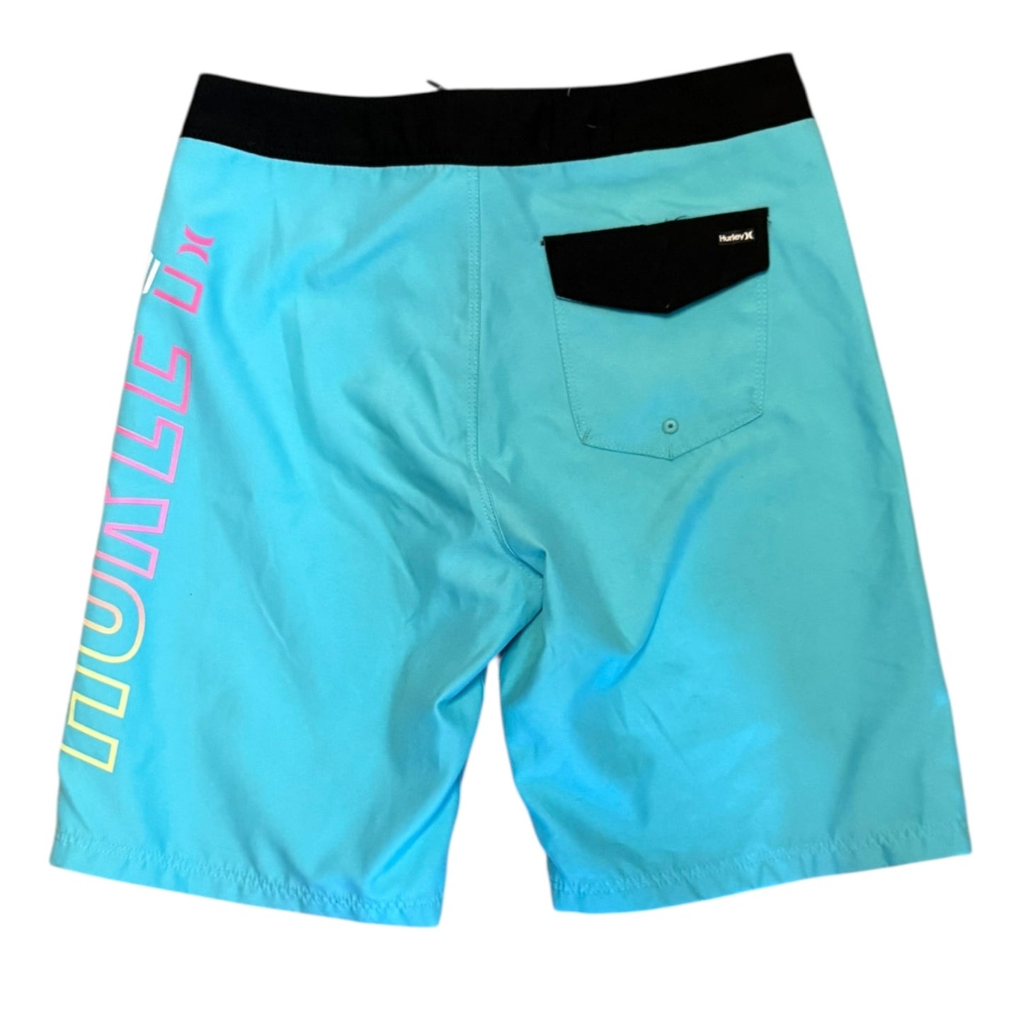 Blue board shorts with a black waistband, a black back pocket, and vertical graphic text on the left leg in yellow, pink, and blue, shown against a plain white background.