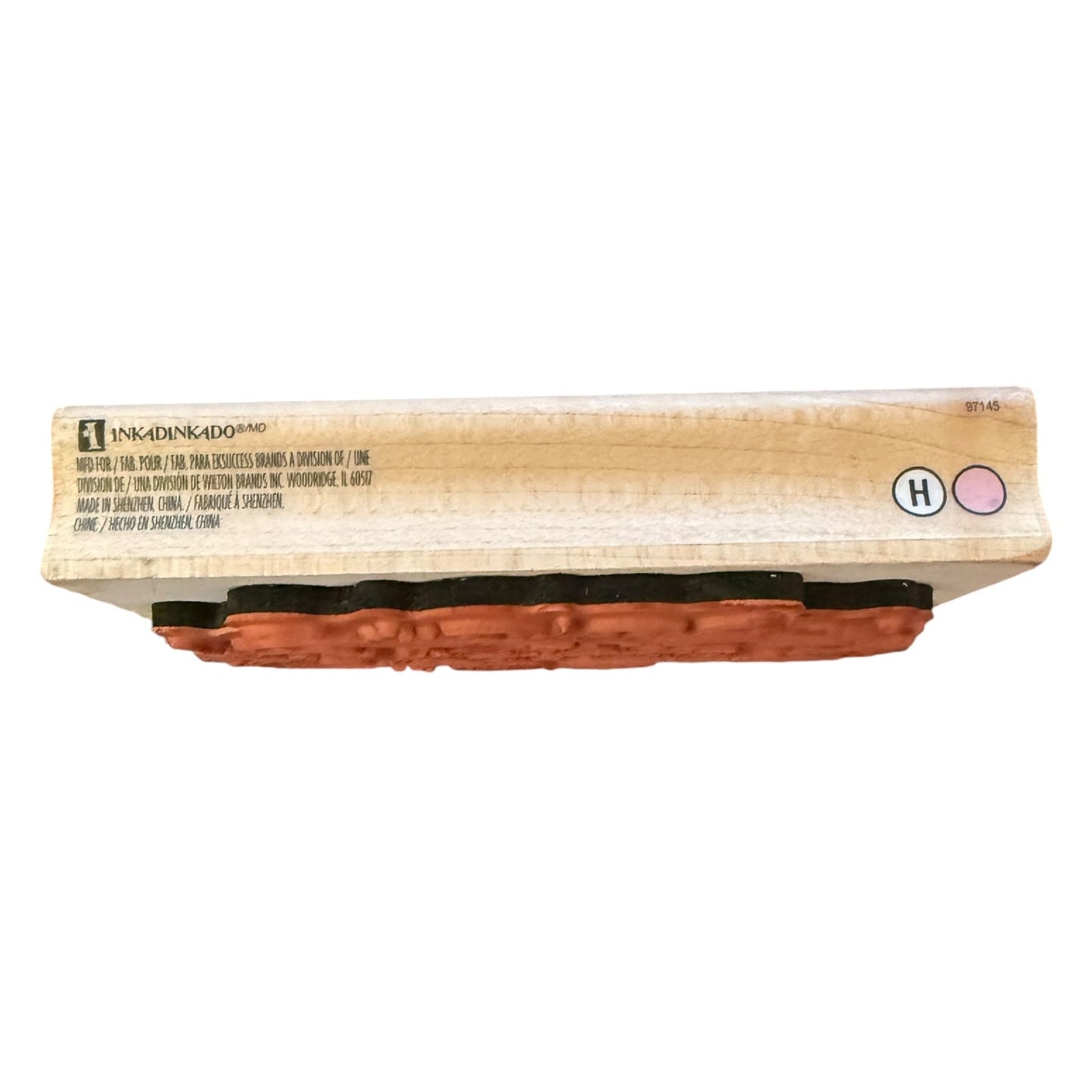 A wooden stamp block, shown from the side on a white background.