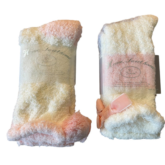 Two plush socks with multicolo color pattern and a pink bow on a white background.