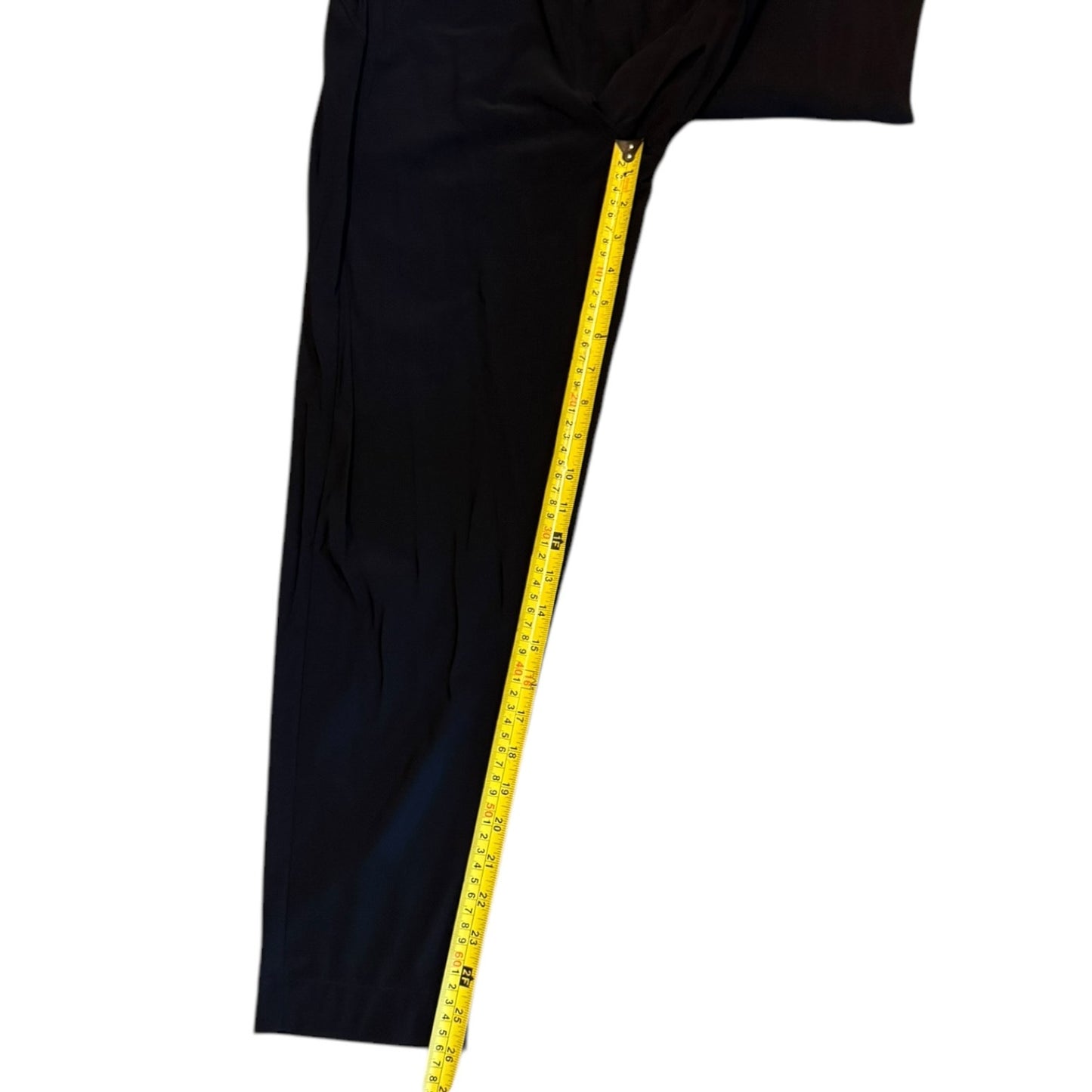 Black pants shown on with a yellow measuring tape running down the side to indicate length, against a plain white background.