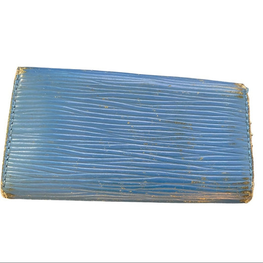 Back of blue keychain holder from Louis Vuitton texture on a white background