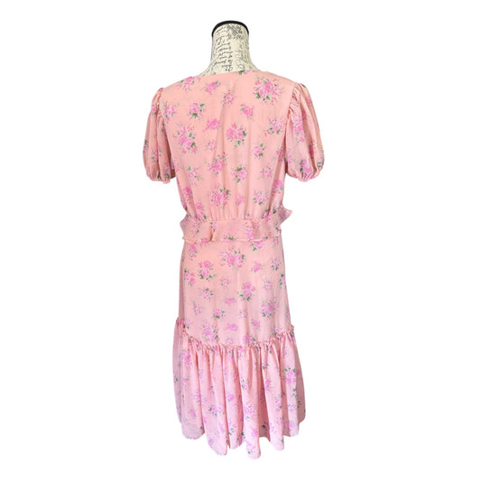 A pink short-sleeve dress with a pink and green floral print, displayed on a mannequin from the back against a white background.