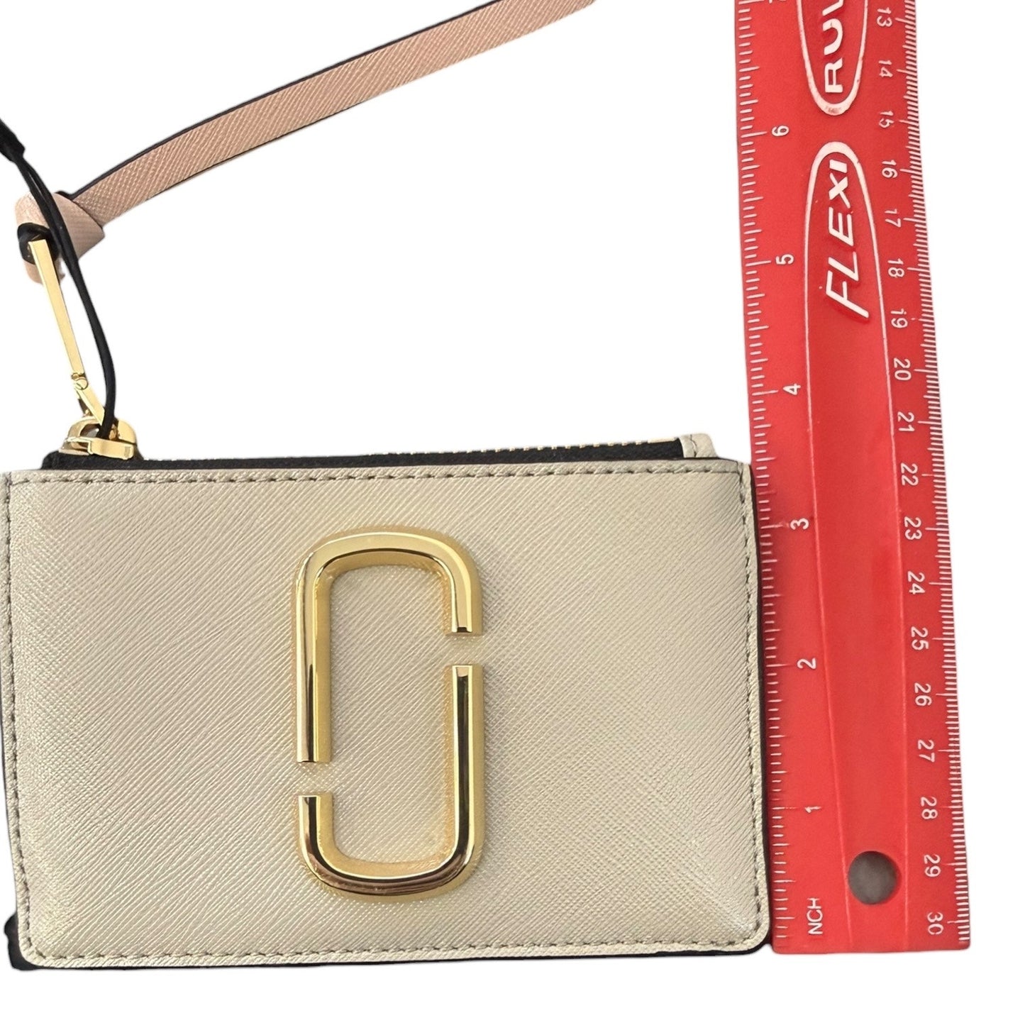 Beige pouch with gold clasp next to a red ruler for size reference 3.5"H