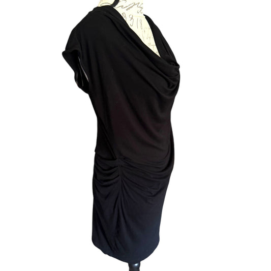 Black draped dress on a mannequin against a white background