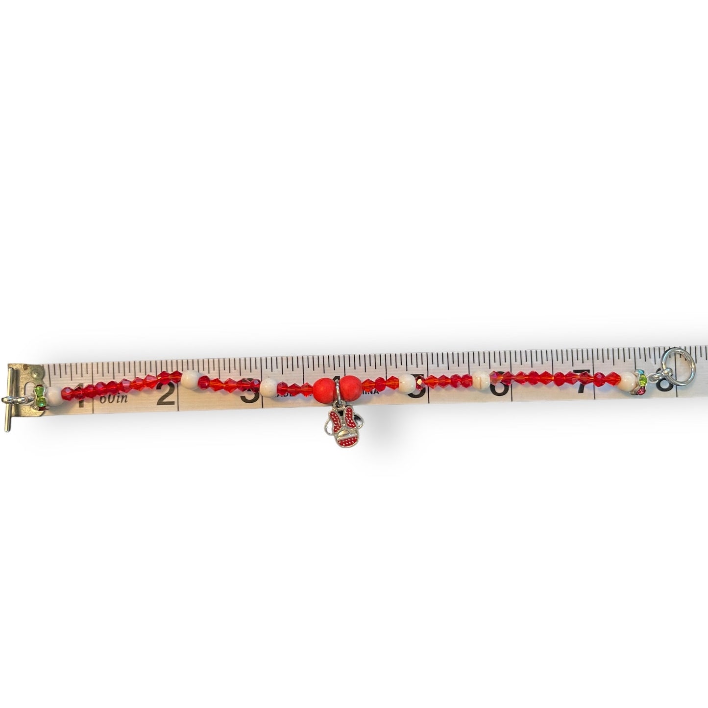 A beaded bracelet , displayed horizontally on a measuring tape against a white background.