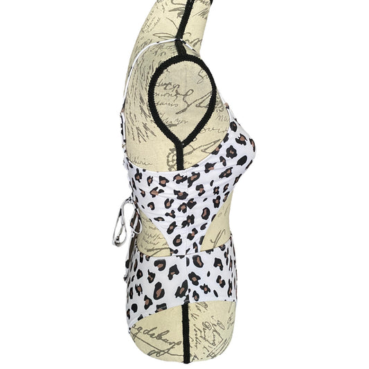 A women's bikini-style top displayed on a dress form mannequin, featuring a split design with a white leopard print section and a beige vintage script print section, accented with black trim.