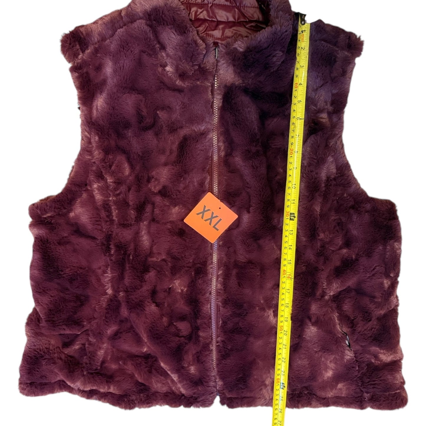 fur vest with an orange size tag and yellow measuring tape on a white background