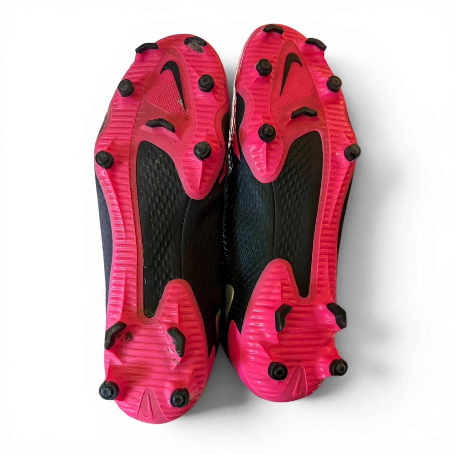Pair of pink and black sports shoes with cleats on a white background