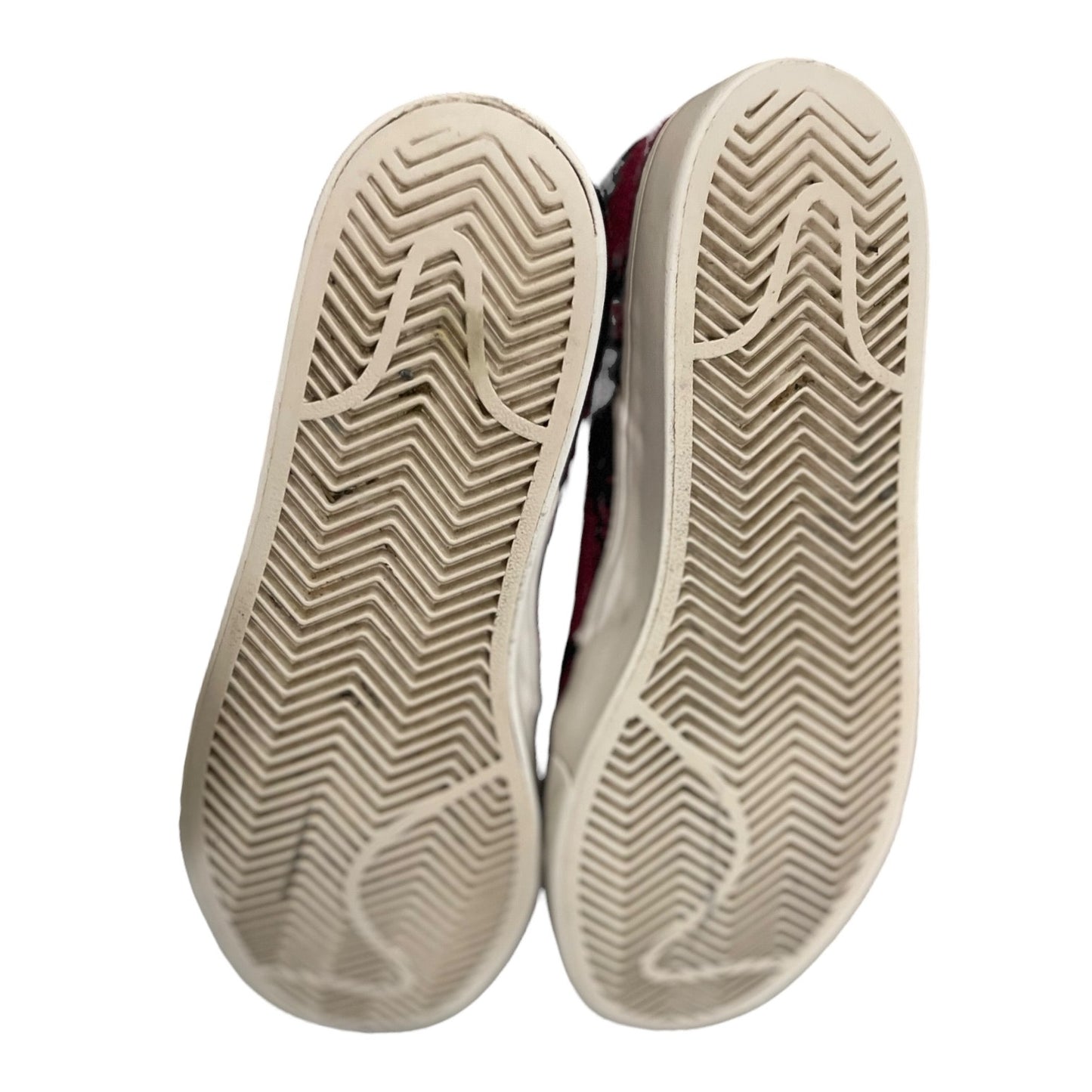 A pair of athletic shoes shown from the sole view, highlighting their textured chevron-patterned rubber outsoles against a plain white background.