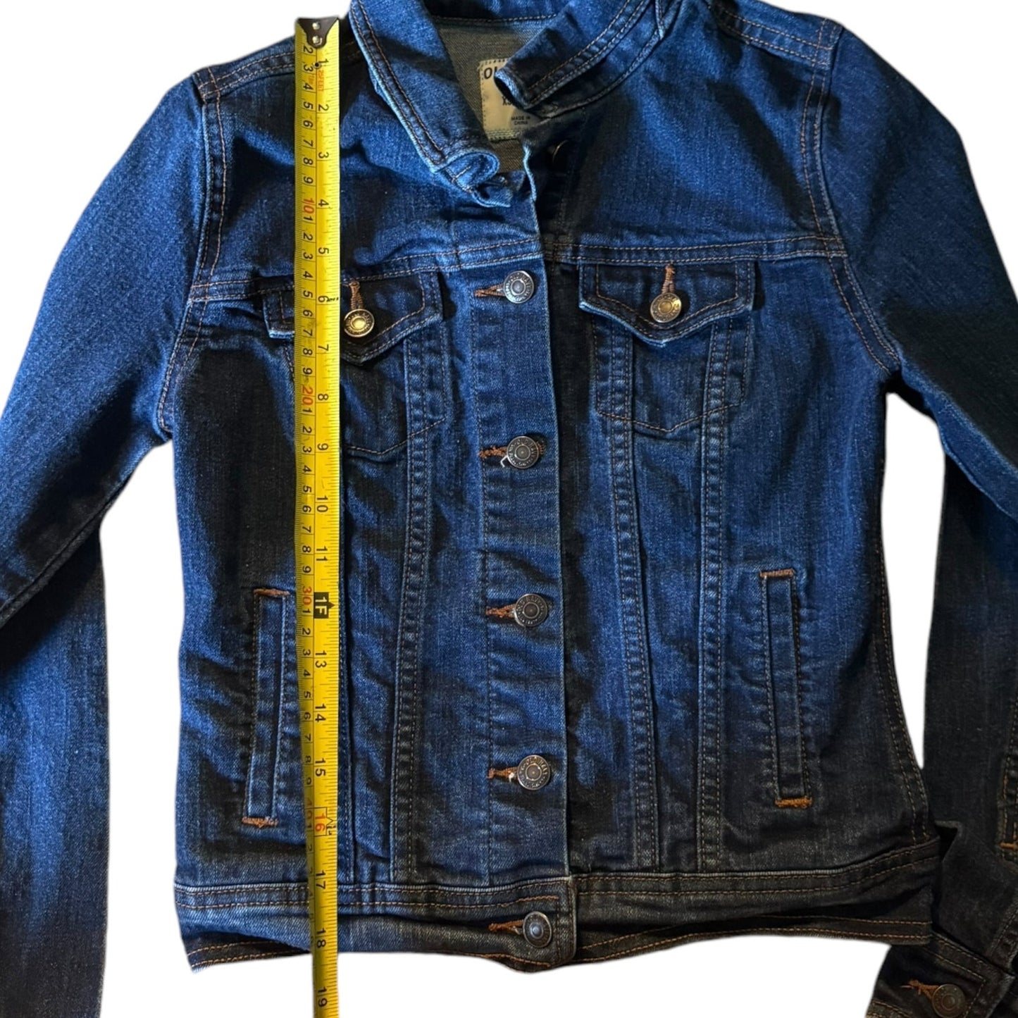 Blue denim jacket with a measuring tape for size reference on a white background
