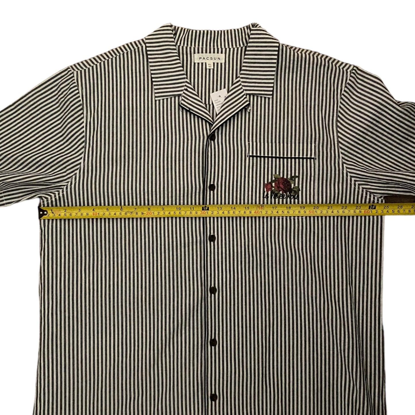 Gray and white striped shirt with a measuring tape on a white background