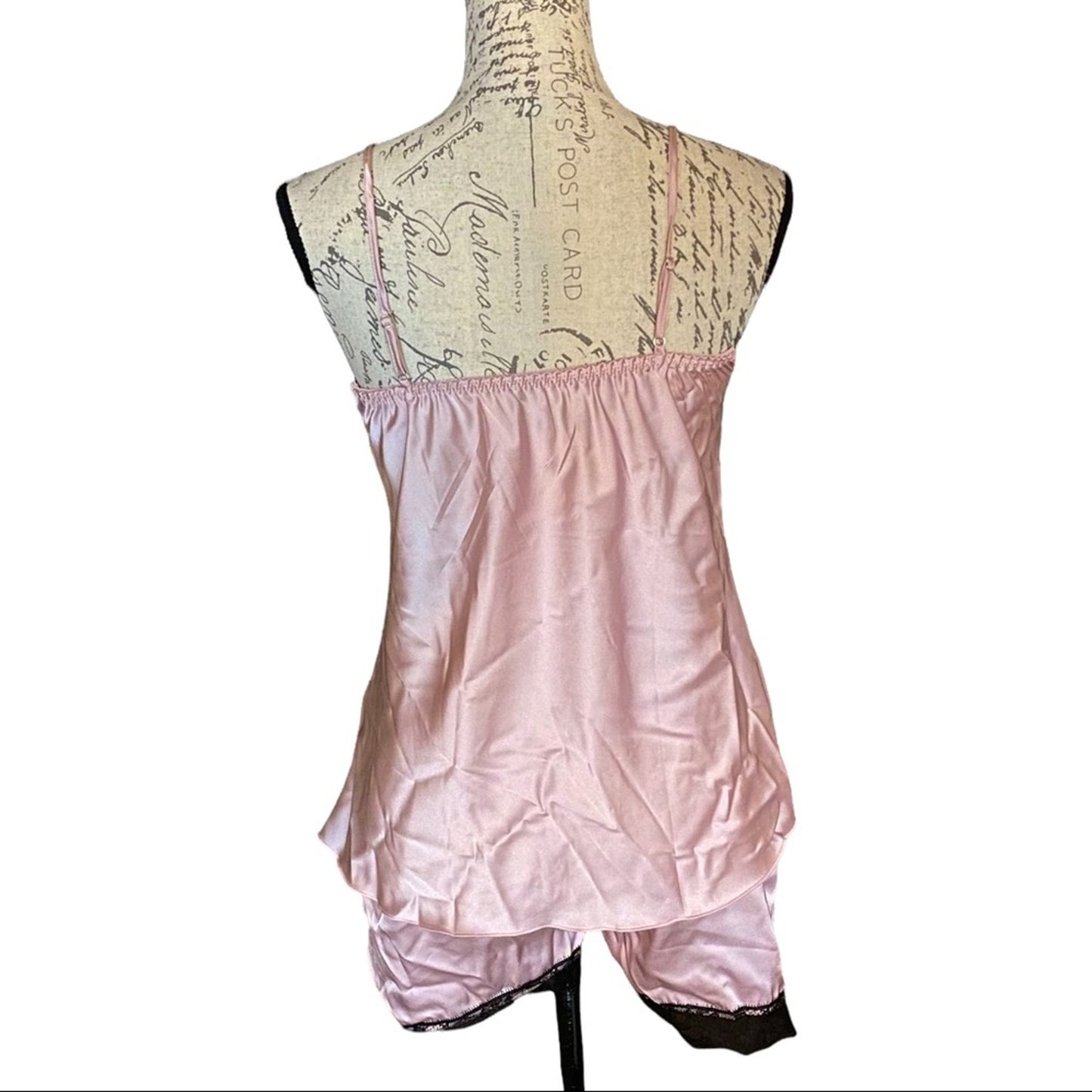 Light pink sating pajama set on a mannequin with a decorative background