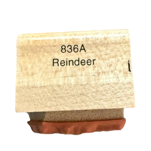 A wooden stamp block with the text '836A Reindeer' printed on the top, resting on a brown paper or rubber stamp surface against a white background.