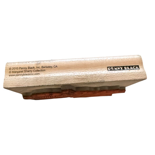A Penny Black rubber stamp shown from a side profile view on a plain white background. The stamp features a light beige textured wooden block with the brand name 'Penny Black' printed in black, and a reddish-brown inked stamp face visible underneath.