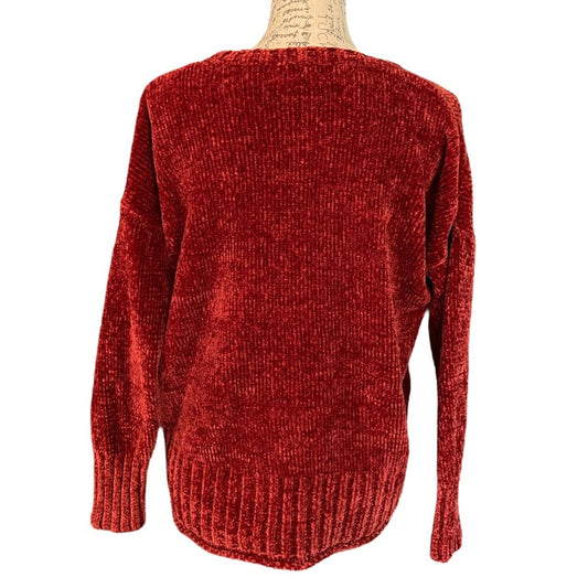 Red/pink knitted sweater on a mannequin with a white background