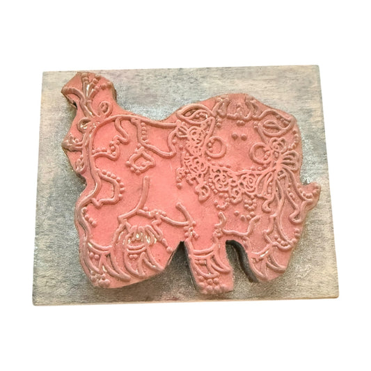 An cow rubber stamp on a wooden block, photographed against a plain white background.