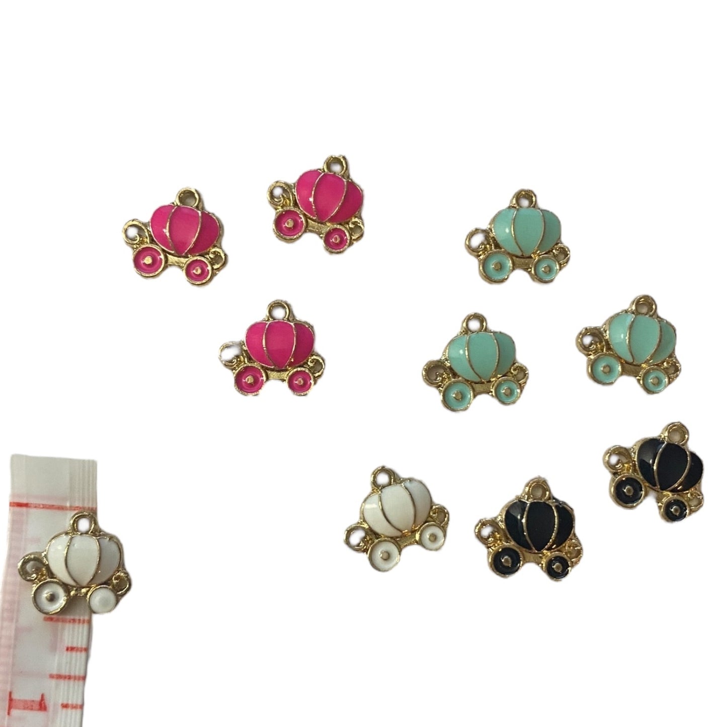 Collection of colorful pumpkin-shaped charms on a white background with a measuring tape for scale.