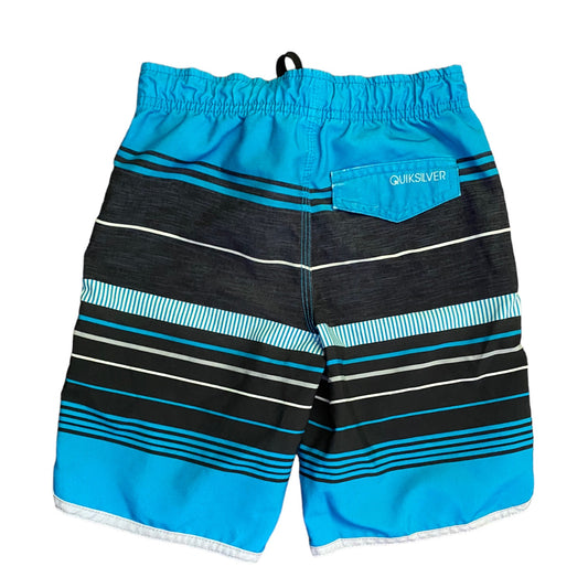 A pair of Quiksilver board shorts with a vibrant blue and black striped pattern, featuring a side pocket with the Quiksilver logo, shown against a plain white background.