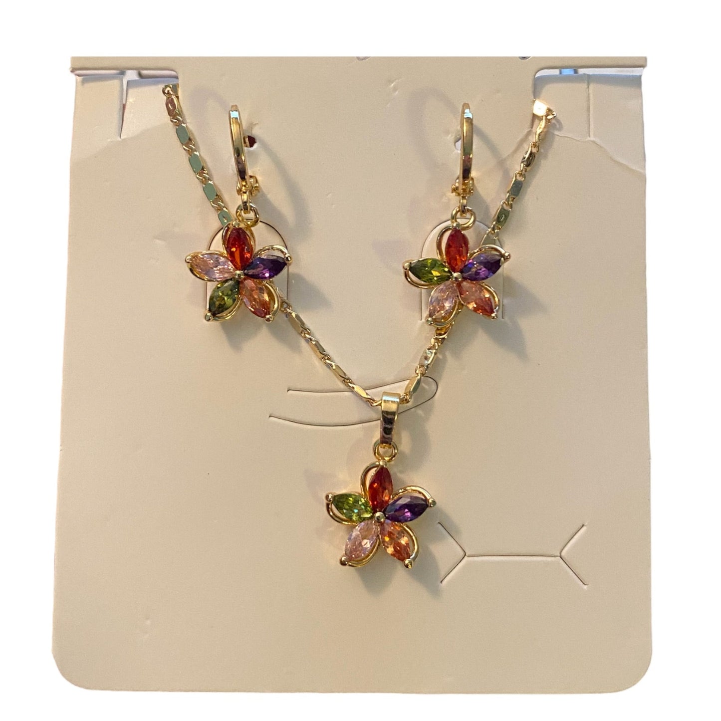 Flower-shaped jewelry set with multicolored stones on a display card.