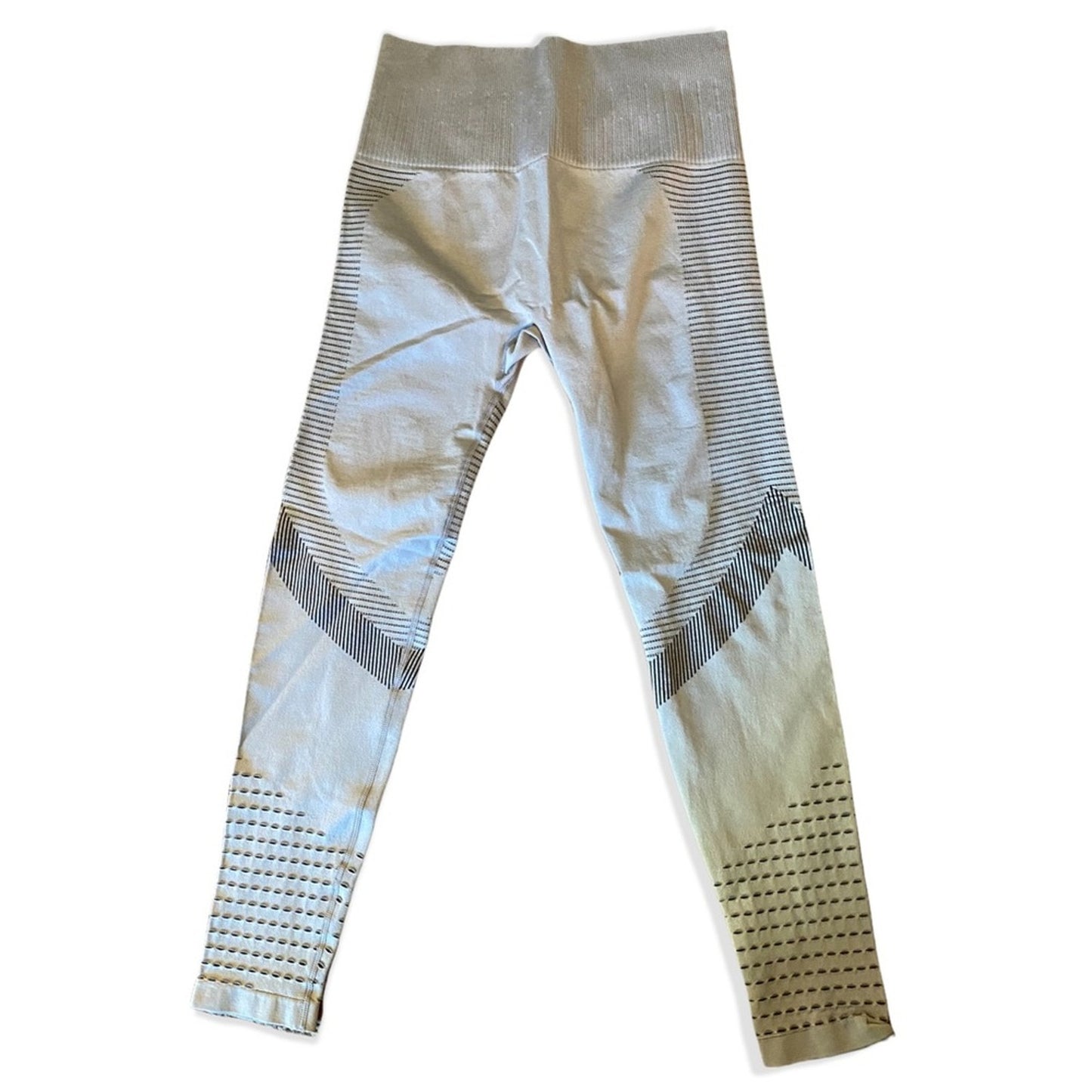 A pair of high-waisted athletic leggings in a gray, featuring textured knit panels, horizontal stripe patterns, and perforated details near the ankles.