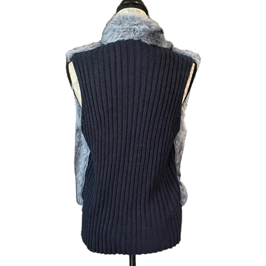 A sleeveless ribbed knit vest in dark navy blue, featuring light
blue faux fur trim along the collar and sides, displayed on a mannequin against a white background.