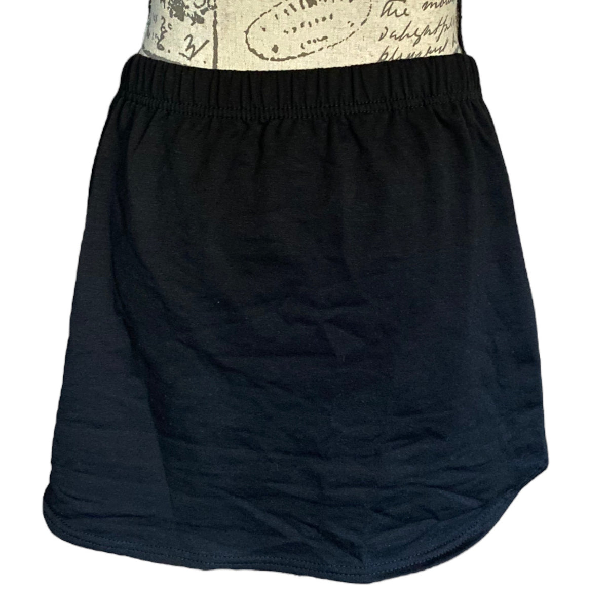 A black skirt with an elastic waistband, displayed on a patterned dress form against a white background.
