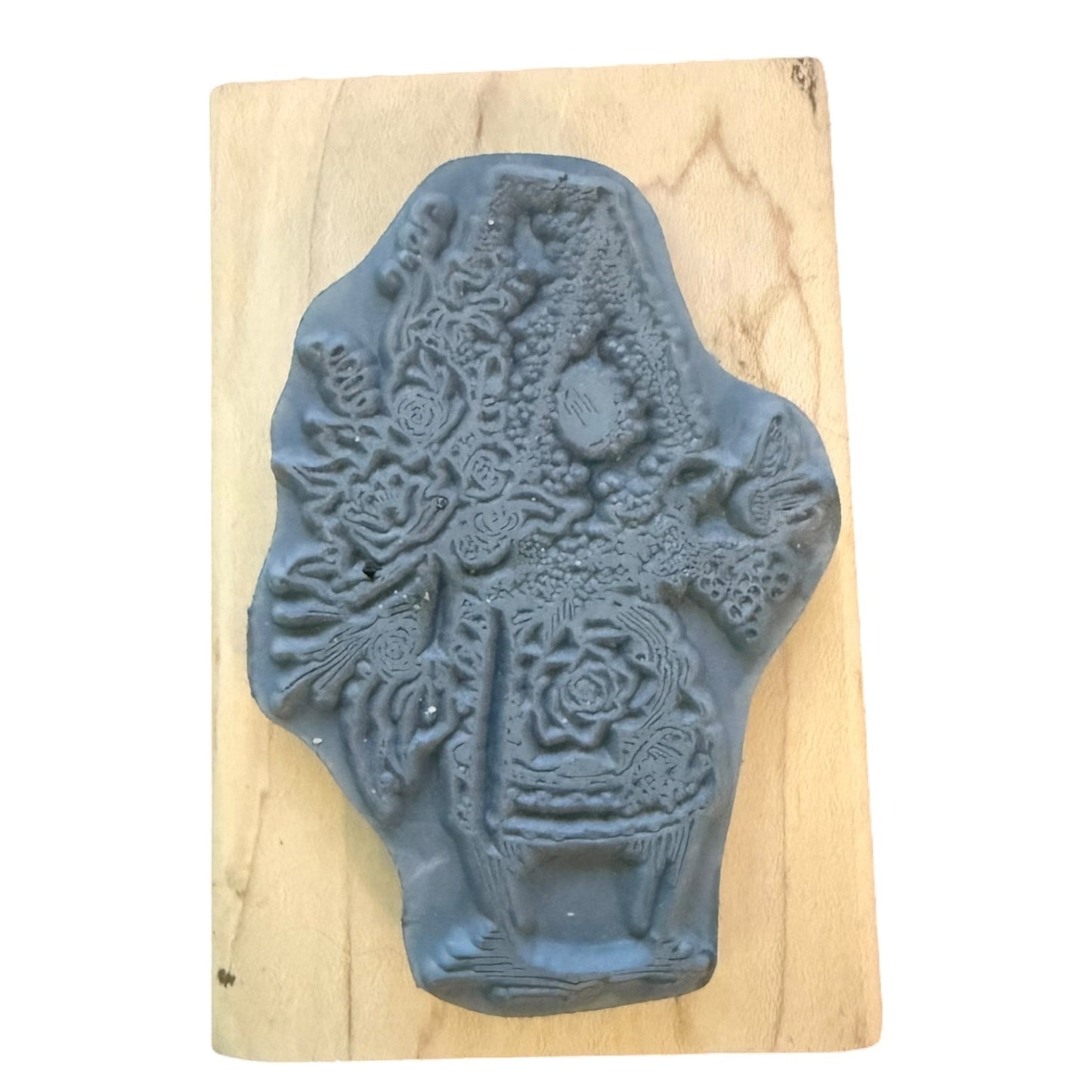 Decorative rubber stamp with intricate design on a wooden block