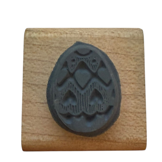 Black egg-shaped stamp on a wooden block