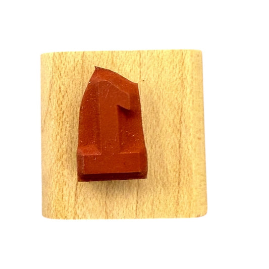 Red letter '1' stamp on a wooden block with a white background