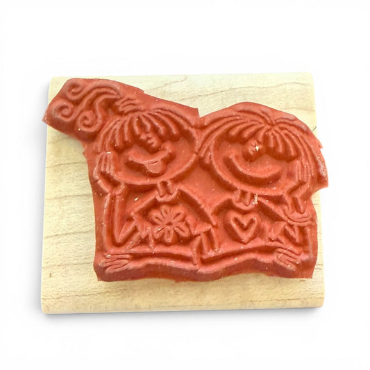 Wooden stamp with red decorative design on a white background