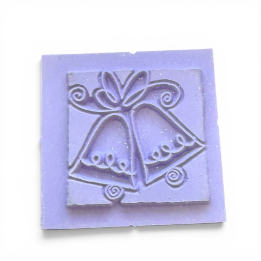 Square stamp with bell design on a light purple background