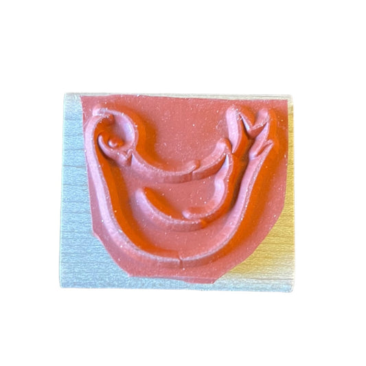 A square wooden stamp block with a bird , set against a white studio backdrop.