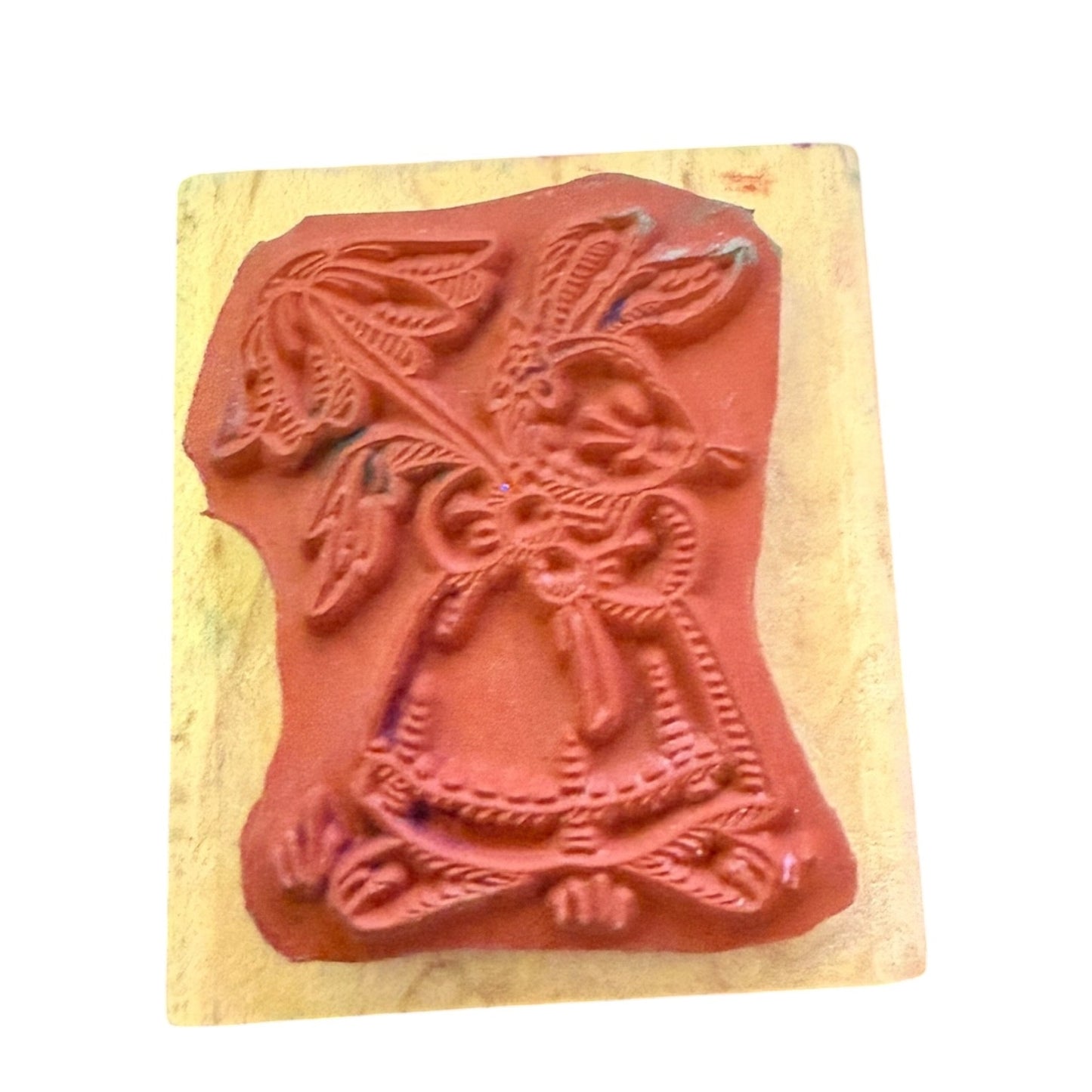 A rubber stamp with an embossed rabbit design, mounted on a light-colored wooden block against a plain white background.