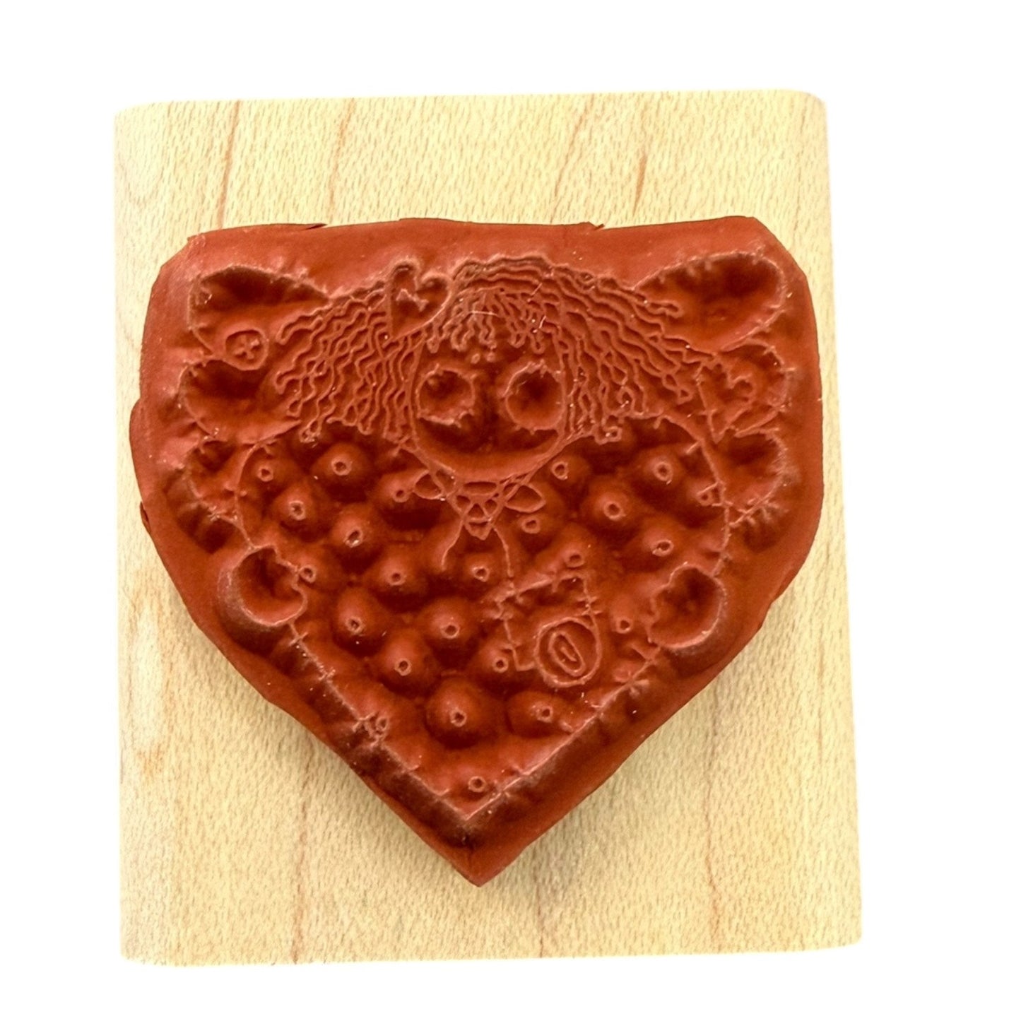 Angel holding a heart stamp design on a wooden block