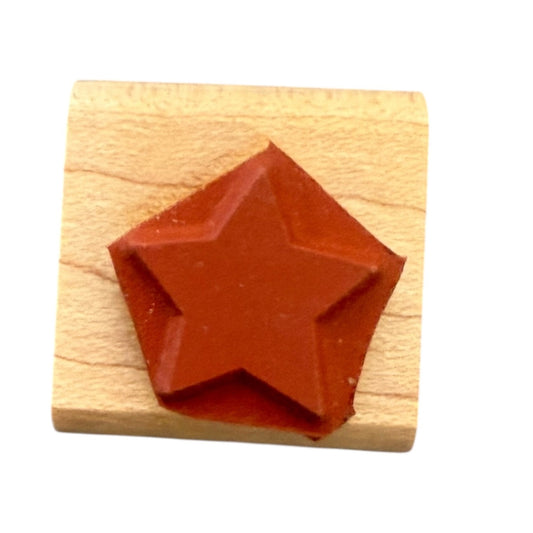 Red star-shaped stamp on a wooden block