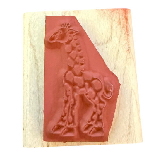 Wooden stamp with a red rubber stamp featuring a giraffe design on a wooden block.