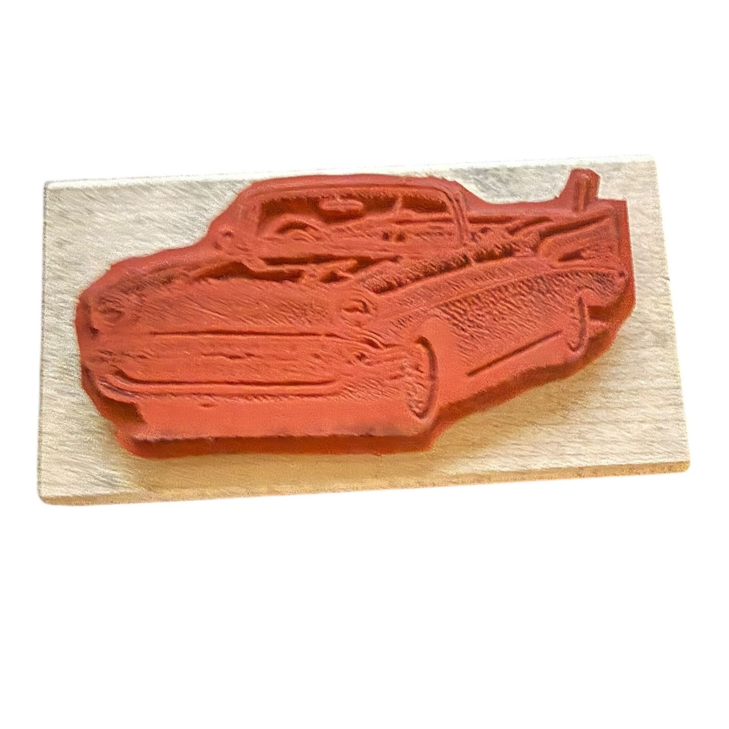 Red car-shaped stamp on a wooden block with a white background