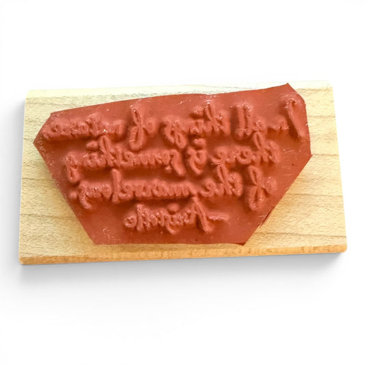 Rubber stamp with engraved text on a wooden block