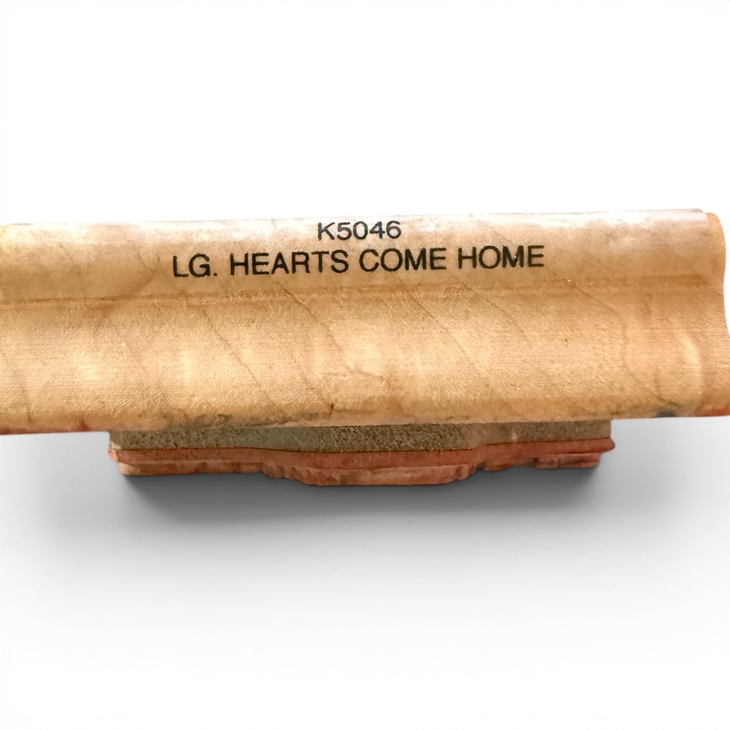 Wooden block with engraved text on a white background