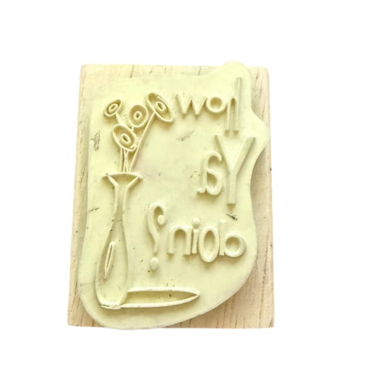 off white rubber stamp on wood block set against a plain white background.