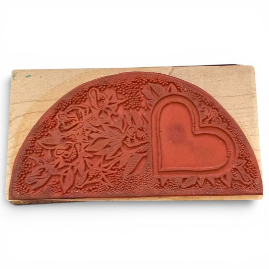 Wooden stamp with floral design and heart shape on a white background