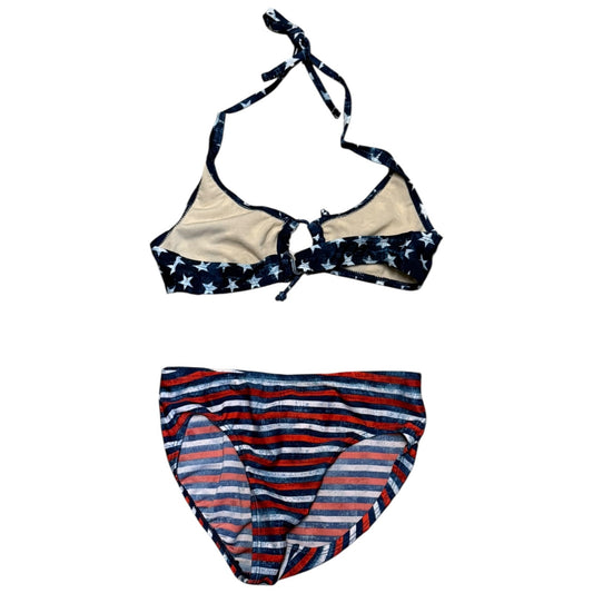 A two-piece bikini set laid flat on a white background. The top is a halter-style bikini with navy blue straps and trim featuring white stars, and beige cups.