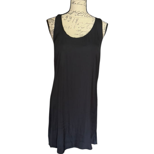 A sleeveless black scoop-neck dress displayed on a vintage-style mannequin torso with cursive writing on the chest, set against a plain white background.