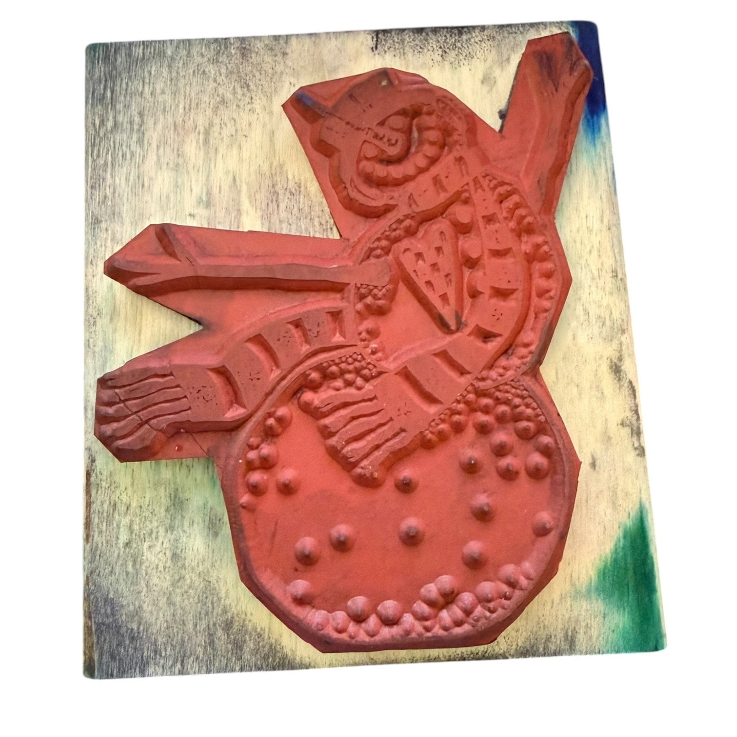 Red decorative rubber stamp on a wooden block with a white background