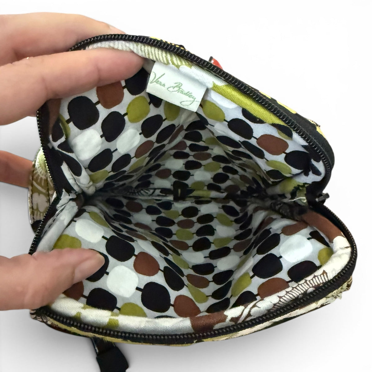 Polka dot fabric inside a small bag with a hand holding it open on a white background