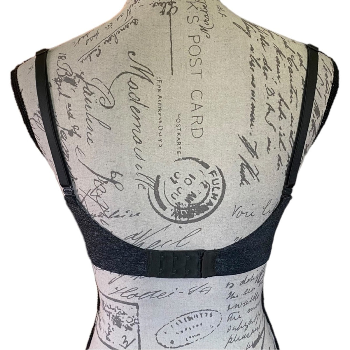 A dark black underwire bra shown from the back on a mannequin