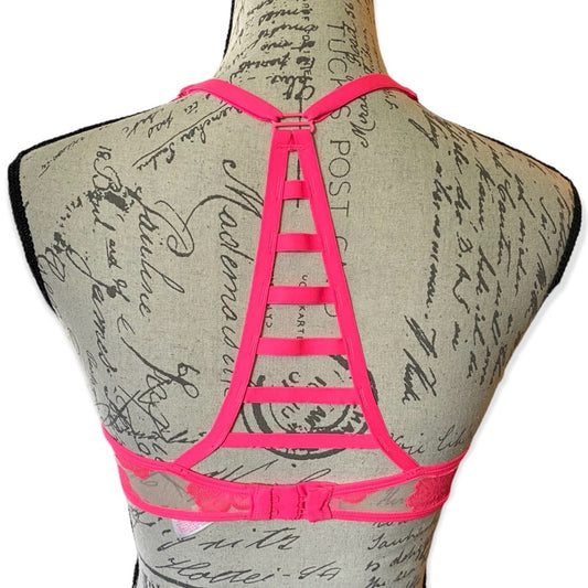 Pink strappy bra on a mannequin with a vintage-style script background