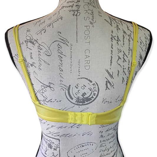 Back of a Mannequin wearing a yellow bra on a white background